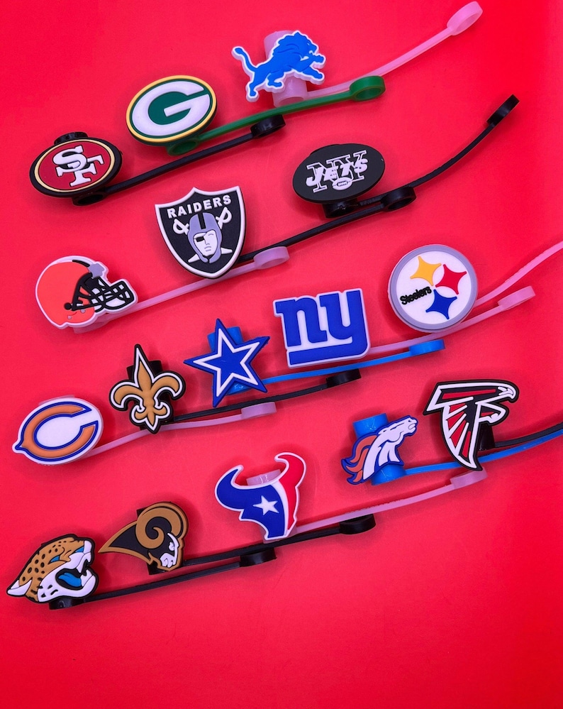 May include: A collection of flexible silicone bands featuring various NFL team logos and mascots, including the Raiders, Steelers, Giants, and Cowboys. Each band is attached to a colorful, molded rubber emblem representing a professional football team.