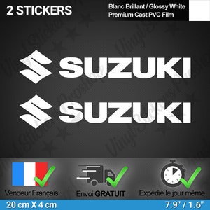 Könnte beinhalten: Zwei weiße Vinyl-Aufkleber mit dem Wort "SUZUKI" in fetten weißen Buchstaben. Die Aufkleber sind 7,9 Zoll mal 1,6 Zoll groß und aus hochwertigem gegossenem PVC-Film.