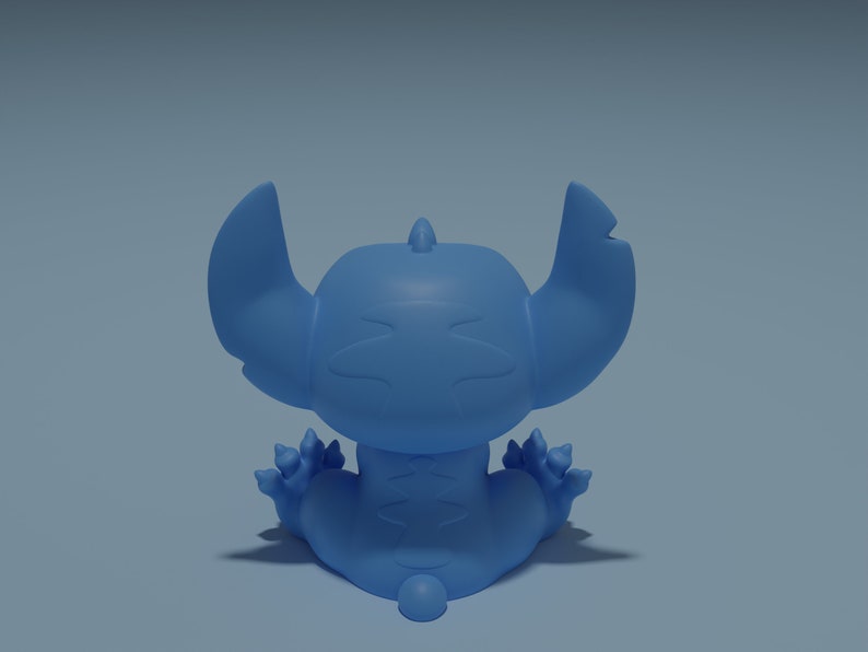 May include: A blue cartoon character with large ears and a stitched design on its body. The character is sitting with its back to the viewer.