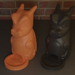 May include: Two ceramic figurines of a cartoon dragon, one orange and one black. Both have a small round base with a hole in the center.