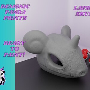 Könnte beinhalten: Ein grauer 3D-gedruckter Lapras-Schädel, bereit zum Bemalen. Der Schädel liegt auf einer schwarzen Oberfläche mit mehreren roten und weißen Pokébällen.