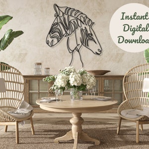 Puede incluir: Una escultura de pared de metal negro de dos cabezas de cebra, con un fondo blanco. La escultura está colgada en una pared en un salón con dos sillas de mimbre, una mesa de madera y plantas.