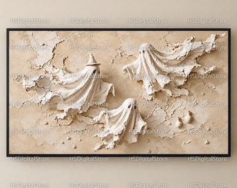 May include: A framed wall art piece featuring three white, textured ghost figures against a cracked, beige background. One ghost wears a small pointed hat, while two small, rounded white objects are positioned near the bottom right.