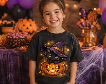 May include: A charcoal gray t-shirt featuring a graphic print of a black kitten wearing a purple witch hat, sitting inside a glowing orange jack-o'-lantern pumpkin surrounded by small yellow stars and autumn leaves on the front of the garment.