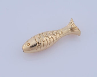 Puede incluir: Un amuleto de pez de color dorado con un diseño detallado. El amuleto está hecho de metal y tiene un acabado liso.