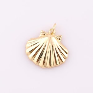 May include: A gold-colored seashell pendant charm. The seashell is detailed with ridges and has a loop at the top for attaching to a necklace or bracelet.