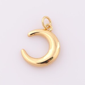 May include: A gold crescent moon charm pendant with a loop for attaching to a necklace or bracelet.