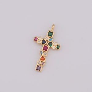 May include: A gold cross pendant with a variety of colorful gemstones, including red, blue, green, and orange.