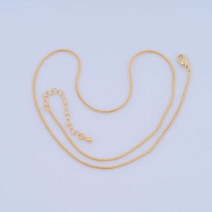 May include: A gold chain necklace with a lobster clasp and an adjustable extension chain.