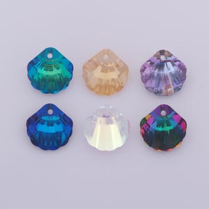 May include: Six iridescent seashell-shaped beads in various colors: teal, amber, lavender, blue, clear, and a multicolored iridescent. Each bead has a hole at the top for stringing. These decorative beads are suitable for jewelry making and craft projects.