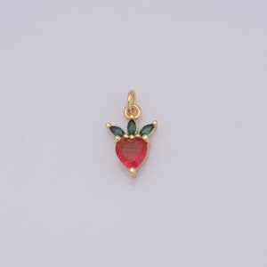 Op de afbeelding: Gouden hangerbedel met een rood hart en groene bladeren.