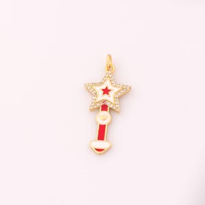 May include: Gold-tone charm with a red and white enamel star with clear rhinestones around the edges. The star is attached to a red and white enamel wand with a gold-tone crown charm.