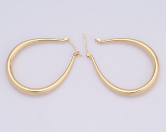 May include: A pair of gold hoop earrings with a smooth, oval shape.