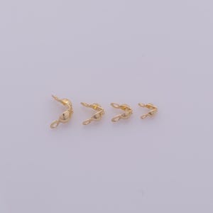 Peut inclure: Quatre embouts de sertissage dor&eacute;s, utilis&eacute;s en bijouterie. Chaque embout a une forme incurv&eacute;e avec une boucle &agrave; une extr&eacute;mit&eacute; et un sertissage &agrave; l'autre. Les embouts sont dispos&eacute;s du plus grand au plus petit.