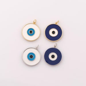May include: Four round evil eye charms with blue and white enamel. Two charms have a gold setting and two have a silver setting.