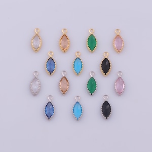 May include: A collection of fourteen marquise-shaped charms featuring faceted glass stones set in metal frames. The charms are arranged in rows and include various colors such as clear, pink, blue, green, and black, each with a small jump ring.