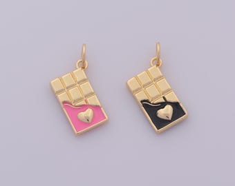 Può includere: Due ciondoli a forma di barretta di cioccolato color oro. Un ciondolo ha un involucro rosa con un cuore dorato, l'altro ha un involucro nero con un cuore dorato. Entrambi i ciondoli hanno un anello color oro.