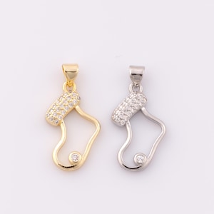 May include: Two gold and silver Christmas stocking charms with clear crystal accents. The charms are in the shape of a stocking with a small round crystal at the toe.