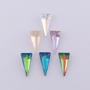 May include: Six iridescent crystal pendants in a triangular shape. The pendants are in various colors, including clear, peach, and shades of blue and green. Each pendant has a hole at the top for stringing.