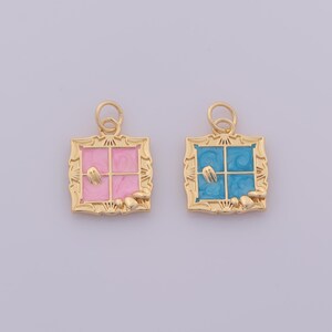 Könnte beinhalten: Zwei goldfarbene Fensteranhänger. Einer hat eine rosa Innenseite, der andere eine blaue Innenseite. Beide haben einen goldfarbenen Rahmen und kleine, goldfarbene Verzierungen unten.