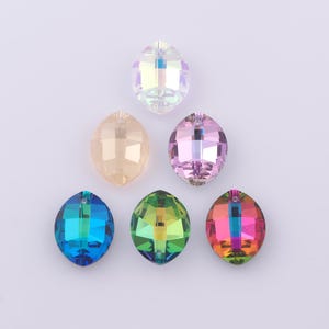 May include: Six faceted, oval-shaped crystal beads in various colours: clear, peach, pink, blue, green, and rainbow. Each bead has a hole at the top for stringing. Suitable for jewellery making and crafts.