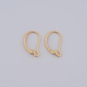 May include: A pair of gold-toned earring hooks. The hooks are made of metal and have a simple, classic design.