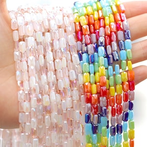 May include: Two strands of faceted glass beads. One strand is iridescent white and the other is rainbow colored.