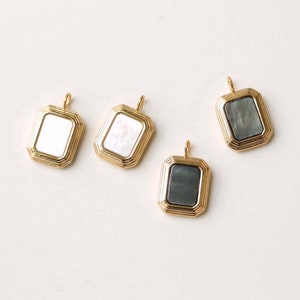 May include: Three gold-toned pendant charms with a rectangular shape and a white or gray mother-of-pearl inlay.