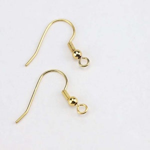 May include: Two gold-toned earring hooks with a small ball at the end of each hook.