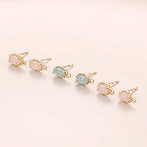 May include: Four pairs of gold-tone earring findings with oval-shaped pastel pink and light blue stones.