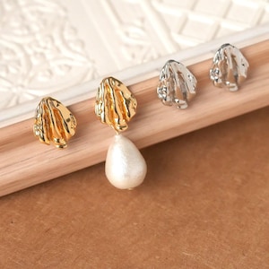 May include: A set of four earrings featuring irregular, textured metal shapes. One earring includes a dangling, teardrop-shaped white pearl. Two earrings are finished in a polished gold tone, while the other two are finished in a polished silver tone.