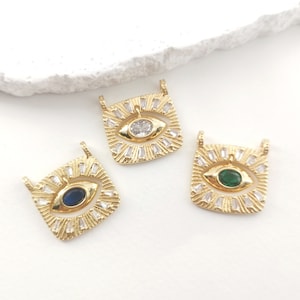 Puede incluir: Tres dijes de ojo turco dorados con un marco cuadrado y piedras transparentes, azules y verdes en el centro. Cada dije tiene un bucle en la parte superior para sujetarlo a un collar o pulsera.