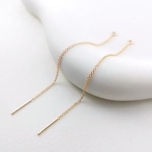 Può includere: Un paio di estensori per orecchini in oro con una catena delicata e un perno sottile e dritto.