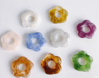May include: Assortment of eight flower-shaped resin hair clips in various colors, including white, pink, blue, green, purple, and brown. Each clip has a swirl pattern and a hole in the center.