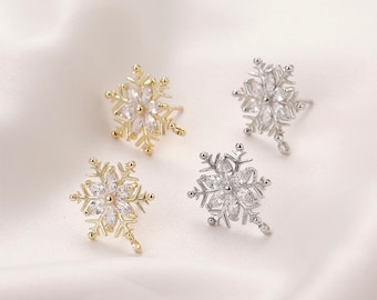 May include: Three snowflake earrings with clear crystal accents. Two earrings are silver and one is gold.