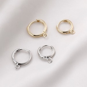 May include: Four hoop earrings with a jump ring. Two are gold and two are silver.