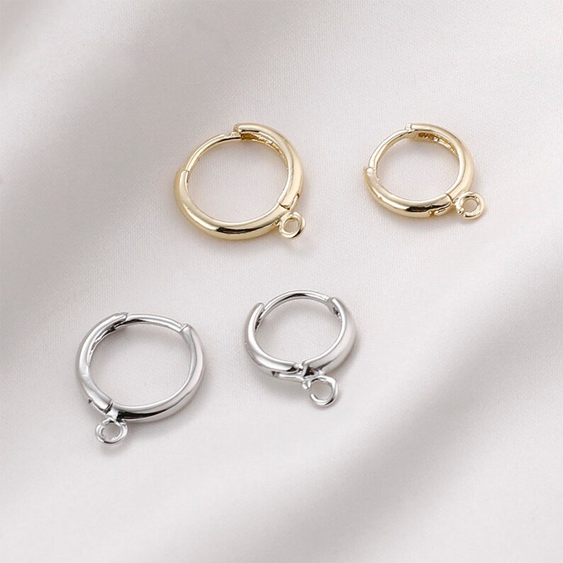 May include: Four hoop earrings with a jump ring. Two are gold and two are silver.