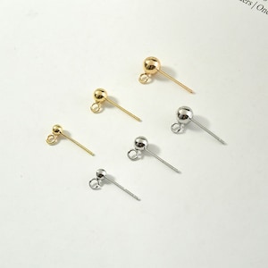 Pode incluir: Cinco postes de brincos com bolas redondas na parte superior. Dois são dourados e três são prateados.