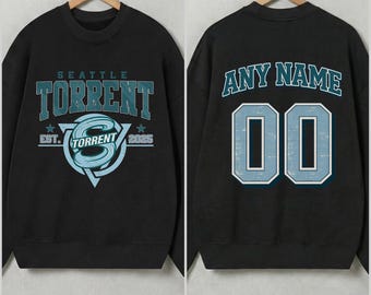 May include: Black sweatshirt with "SEATTLE TORRENT" text and logo on the front, and "ANY NAME" and the number "00" on the back. The design is in teal and white. The sweatshirt is displayed on a wooden hanger.