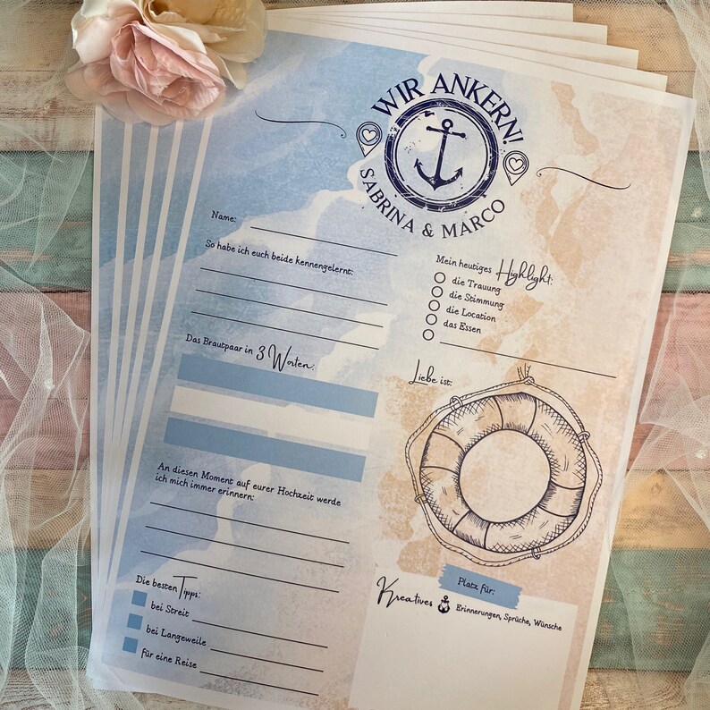 May include: A stack of nautical-themed wedding guest book pages. The design features an anchor, life preserver, and text in blue and brown tones. The text includes "WIR ANKERN!" and the names "SABRINA & MARCO."