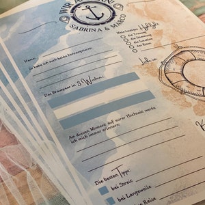 May include: A stack of nautical-themed wedding guest cards with blue and tan watercolor backgrounds. The cards feature an anchor graphic, the names "Sabrina & Marco", and fill-in-the-blank prompts. The text includes "Wir Ankern!" and "Die besten Tipps".