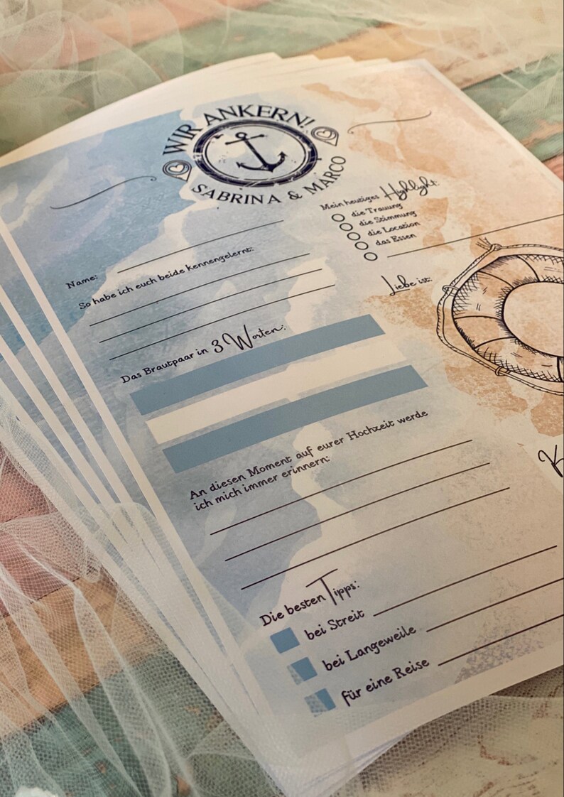 May include: A stack of nautical-themed wedding guest cards with blue and tan watercolor backgrounds. The cards feature an anchor graphic, the names "Sabrina & Marco", and fill-in-the-blank prompts. The text includes "Wir Ankern!" and "Die besten Tipps".