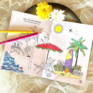 May include: A coloring book with the title "Die Hochzeitsreise" and the text "Male das Bild bunt an" which translates to "The Honeymoon" and "Color the picture brightly". The book features a variety of images including palm trees, a beach chair, a surfboard, a turtle, a beach umbrella, a hut, and a sun.