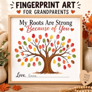 May include: A square framed print featuring a tree illustration with colorful fingerprint leaves in shades of red, orange, yellow, and green. The text reads My Roots Are Strong Because of You and Love, Emma. The frame is light wood.