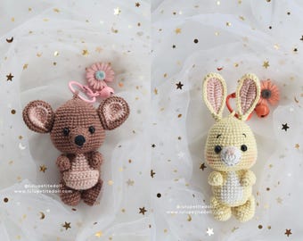 May include: Two handmade crochet keyrings: a brown koala and a yellow bunny. The koala has large ears and a pink pouch. The bunny has long ears with pink insides and rosy cheeks. Both have key rings and are set against a star-speckled background.