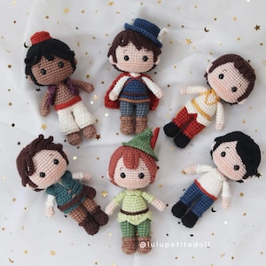 Pode incluir: Seis bonecos de crochê feitos à mão com diversas roupas e penteados, incluindo personagens com vestimentas vermelhas, azuis, verdes e brancas. Cada boneco tem traços faciais bordados e cabelo de lã. O texto lulupetitedoll é visível abaixo.