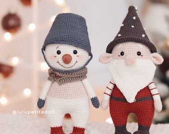 May include: A crocheted snowman and elf doll, both standing on a white surface. The snowman is wearing a blue hat and a brown scarf. The elf is wearing a brown hat with white polka dots and a red and white striped shirt.