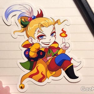 Könnte beinhalten: Ein bunter Cartoon-Aufkleber mit einer Figur mit gelben Haaren, roten und blauen Kleidern und einer Flamme über dem Kopf. Die Figur lächelt und hat einen schelmischen Ausdruck.