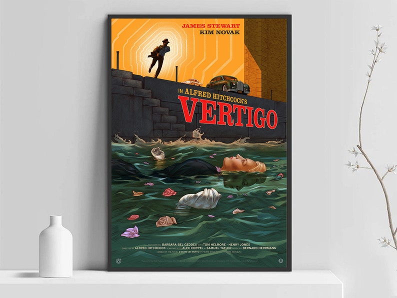 May include: A framed movie poster for Alfred Hitchcock's "Vertigo." The artwork features a man running, a woman in water, and the title in red. The poster has a vintage style with a color palette of orange, black, and green.