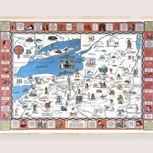 May include: A framed vintage map of a region with blue water and land in shades of tan, green, and brown. The map is filled with illustrations of people, animals, and landmarks. The frame is light-colored wood.